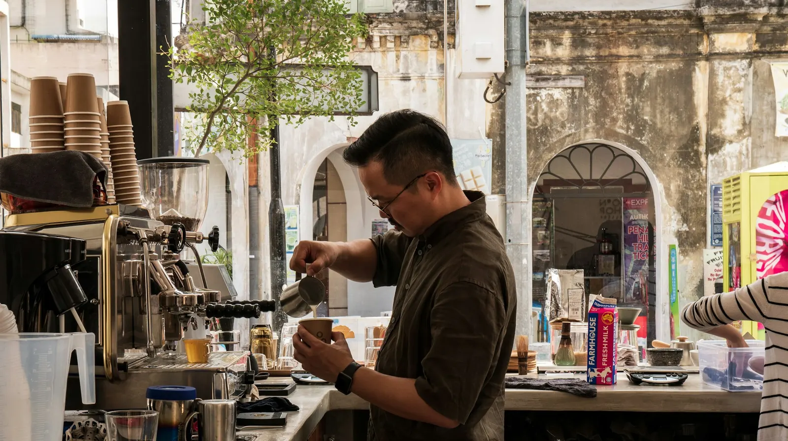 Barista preparando un café en la barra de su cafetería