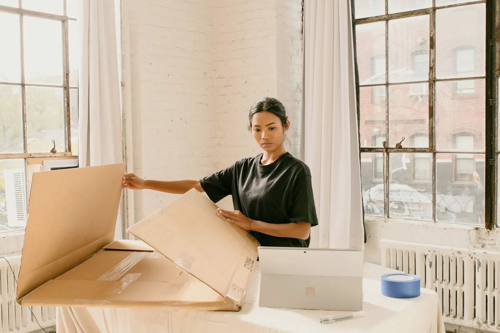 Una emprendedora prepara un pedido en cajas de cartón en su taller